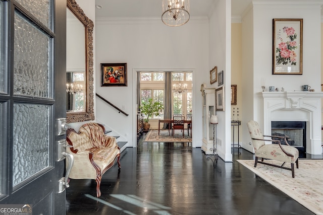 living area featuring an inviting chandelier, crown molding, and dark hardwood / wood-style floors