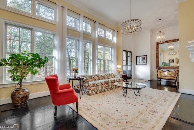 living room with crown molding, dark wood-type flooring, and a chandelier