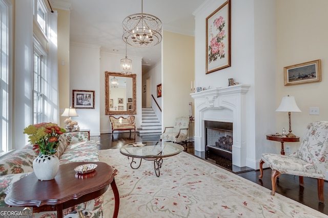 living room featuring ornamental molding, dark hardwood / wood-style floors, and a notable chandelier