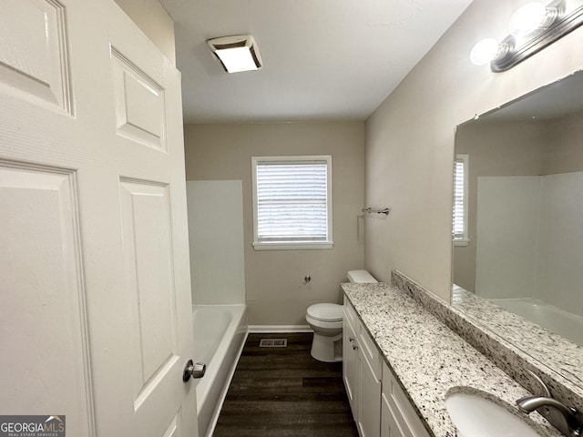 bathroom with hardwood / wood-style floors, a healthy amount of sunlight, toilet, and vanity