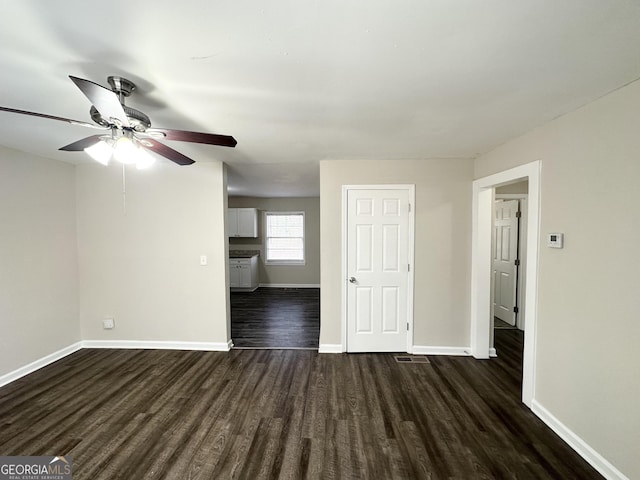 unfurnished room with ceiling fan and dark hardwood / wood-style flooring