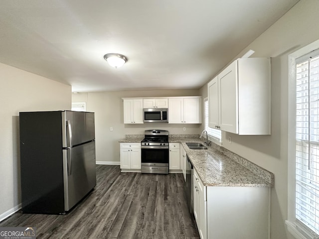 kitchen featuring sink, light stone countertops, white cabinets, and appliances with stainless steel finishes