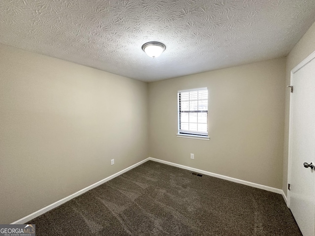 carpeted spare room with a textured ceiling