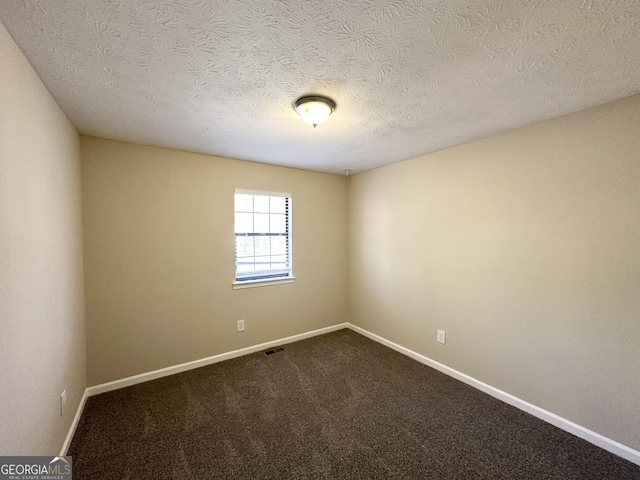 carpeted empty room with a textured ceiling