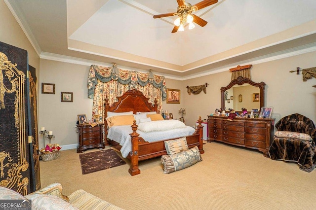 bedroom with ceiling fan, ornamental molding, a raised ceiling, and carpet flooring