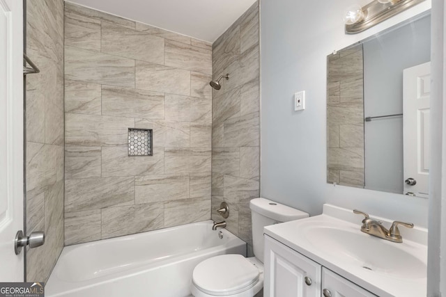 full bathroom featuring tiled shower / bath combo, vanity, and toilet