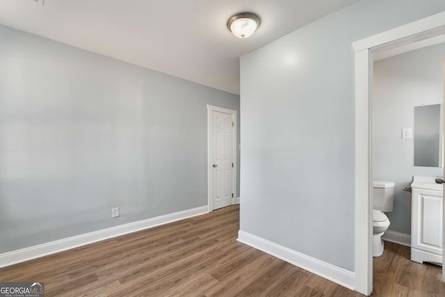 interior space with hardwood / wood-style floors and ensuite bath