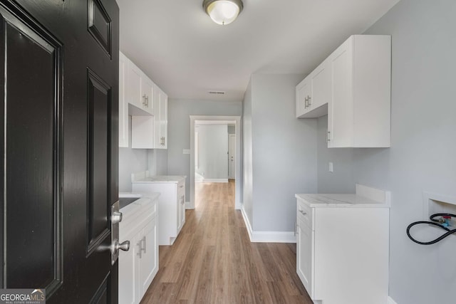 kitchen with white cabinetry and light wood-type flooring