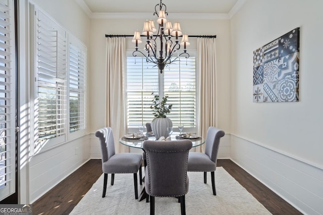 dining space featuring an inviting chandelier, ornamental molding, and dark hardwood / wood-style flooring