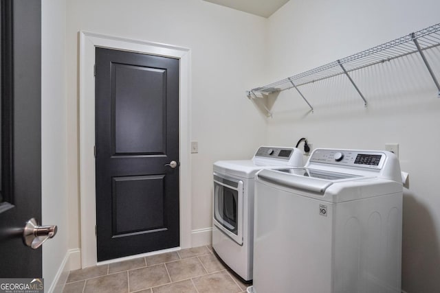 laundry area with washing machine and dryer and light tile patterned floors