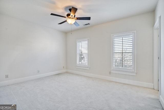 carpeted spare room with ceiling fan and a wealth of natural light