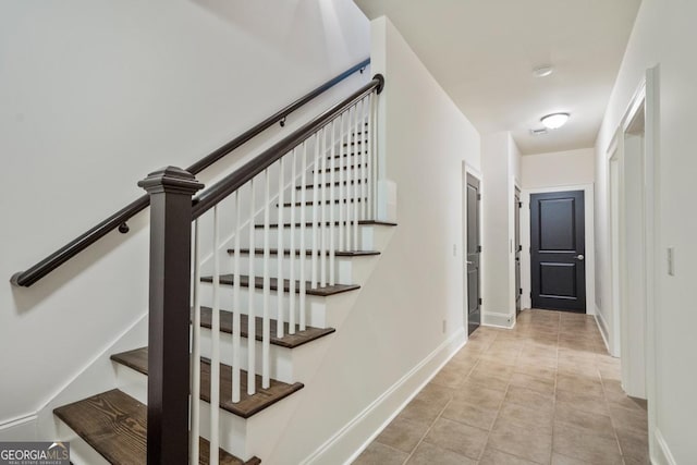 stairway featuring tile patterned flooring