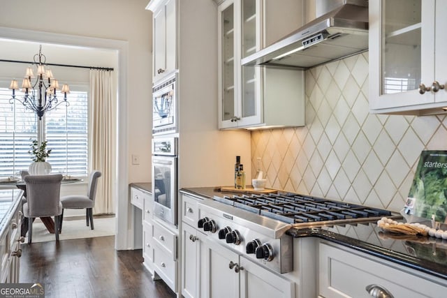 kitchen featuring wall chimney exhaust hood, stainless steel appliances, and white cabinets