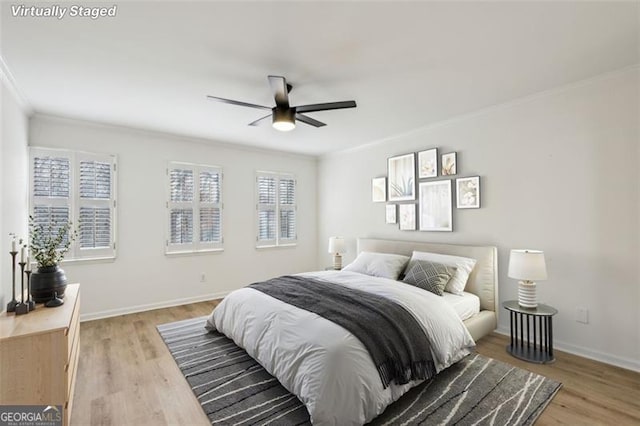 bedroom featuring ceiling fan, ornamental molding, and light wood-type flooring