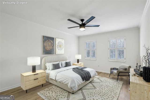 bedroom with ceiling fan, wood-type flooring, and ornamental molding