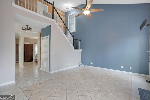 tiled spare room featuring a high ceiling and ceiling fan