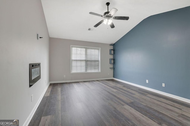 unfurnished room featuring heating unit, vaulted ceiling, dark hardwood / wood-style floors, and ceiling fan