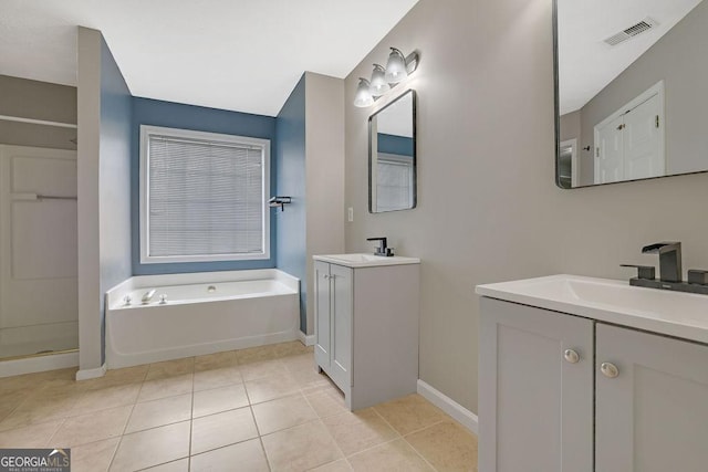 bathroom with tile patterned flooring, a bath, and vanity