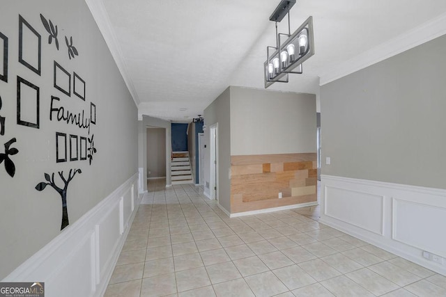 hall with crown molding, light tile patterned floors, and a chandelier