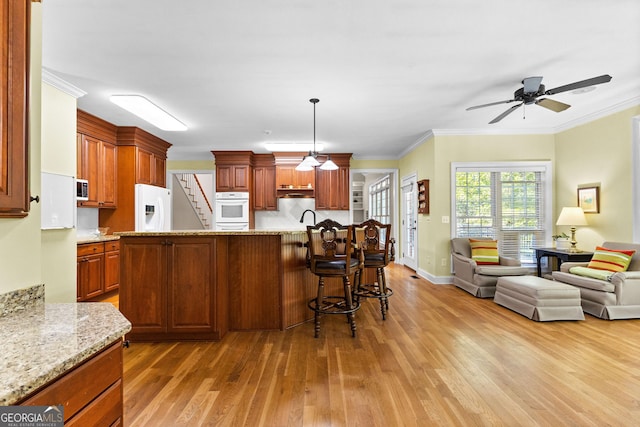 kitchen featuring open floor plan, white appliances, and light wood-type flooring