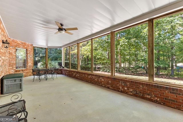 unfurnished sunroom featuring a ceiling fan