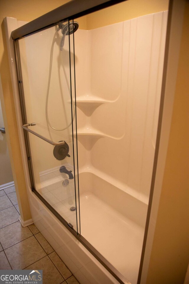 bathroom with a shower with shower door and tile patterned flooring