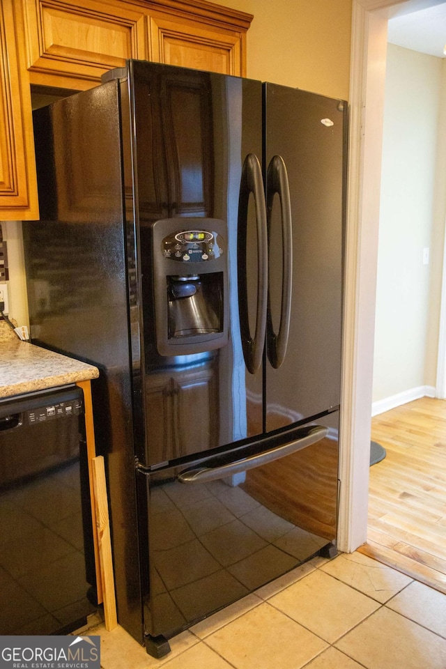 interior space with light tile patterned floors and black appliances