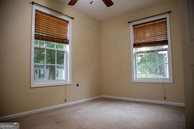 carpeted spare room with ceiling fan and a wealth of natural light