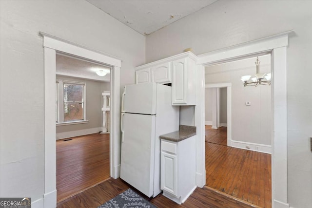 kitchen featuring a chandelier, white cabinetry, dark hardwood / wood-style flooring, and white fridge