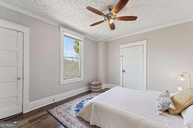 bedroom with ceiling fan, a textured ceiling, dark hardwood / wood-style floors, and crown molding