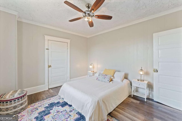 bedroom with hardwood / wood-style flooring, a textured ceiling, ceiling fan, and ornamental molding