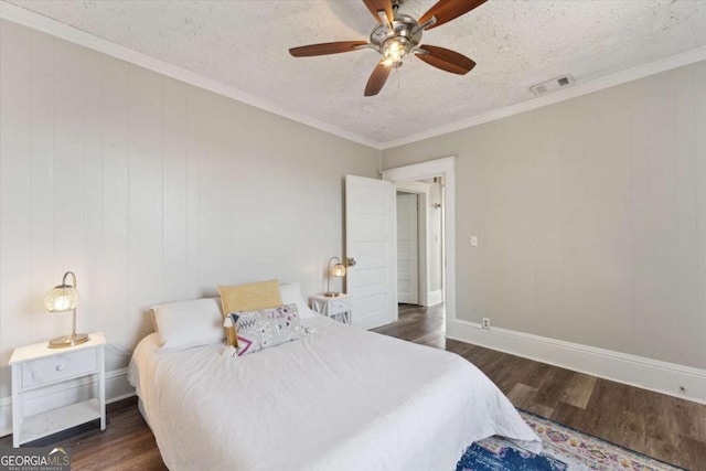 bedroom featuring crown molding, dark wood-type flooring, a textured ceiling, and ceiling fan