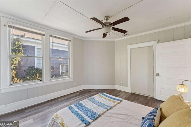 bedroom with ceiling fan, ornamental molding, and dark hardwood / wood-style floors