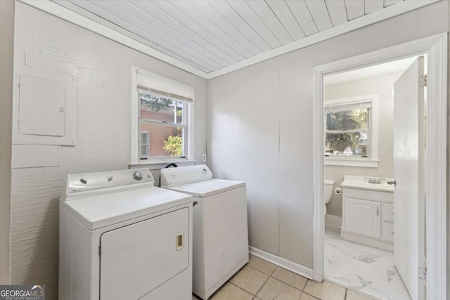 laundry area featuring wood ceiling, sink, light tile patterned floors, and independent washer and dryer