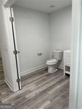 bathroom with hardwood / wood-style floors and toilet