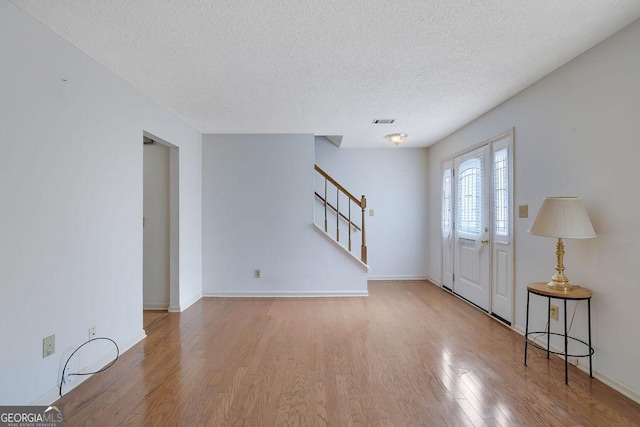 entrance foyer with wood-type flooring and a textured ceiling