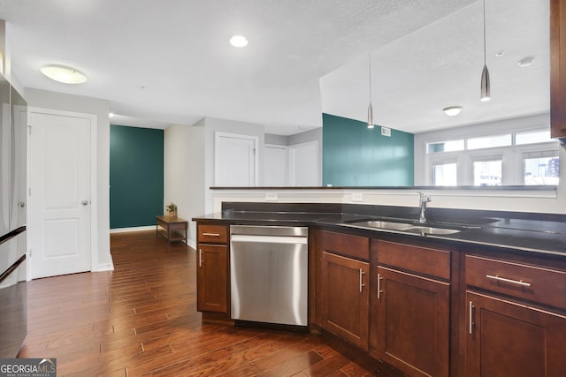 kitchen featuring sink, dishwasher, a textured ceiling, and dark hardwood / wood-style flooring