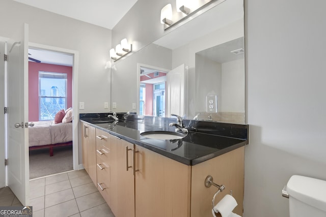 bathroom with toilet, vanity, and tile patterned flooring