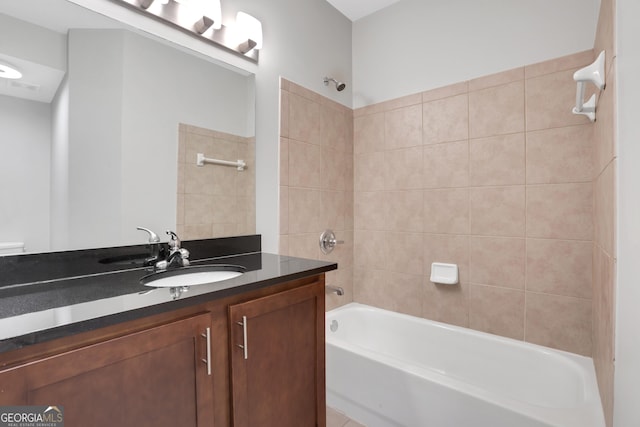 bathroom featuring vanity and tiled shower / bath