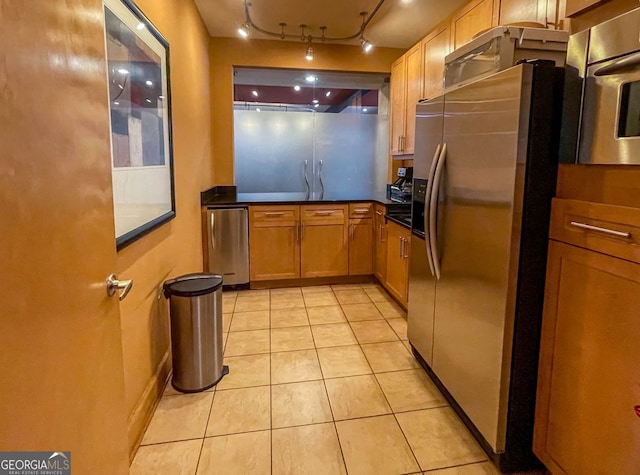 kitchen with refrigerator, light tile patterned floors, and stainless steel fridge