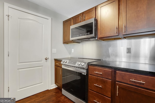 kitchen featuring dark wood-type flooring and appliances with stainless steel finishes