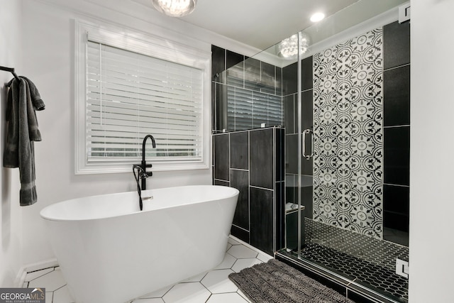 bathroom featuring tile patterned flooring, a stall shower, and a soaking tub