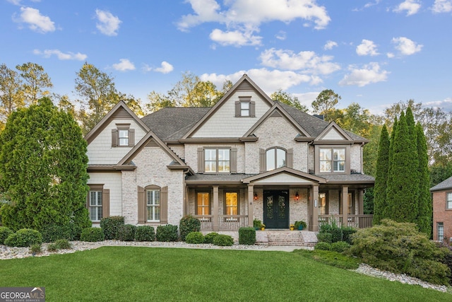 view of front of property featuring covered porch and a front yard