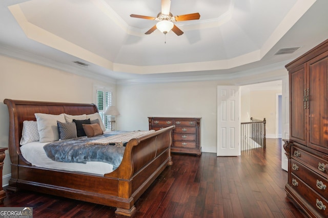 bedroom featuring ceiling fan, crown molding, dark hardwood / wood-style flooring, and a raised ceiling