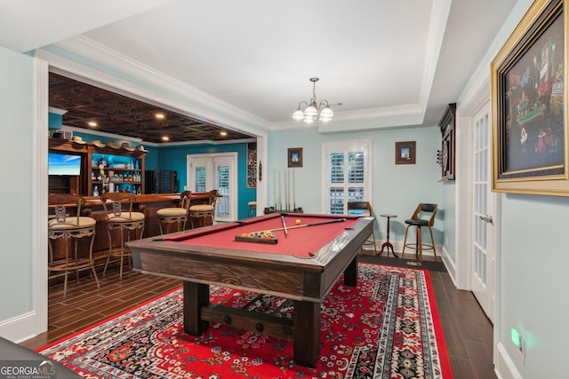 game room with billiards, bar area, ornamental molding, and dark wood-type flooring