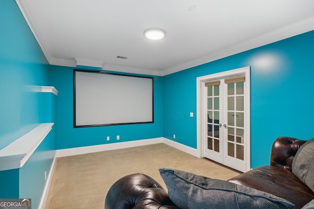 carpeted home theater with ornamental molding and french doors