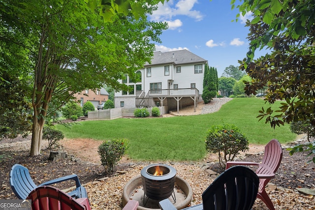 view of yard featuring a deck and an outdoor fire pit