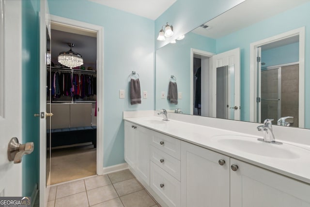 bathroom featuring tile patterned flooring, a shower with shower door, and vanity