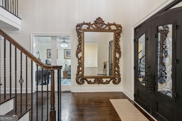 entryway featuring dark wood-type flooring, a towering ceiling, and french doors