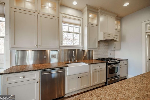 kitchen featuring sink, tasteful backsplash, dark stone counters, and stainless steel appliances